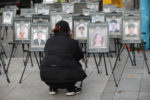 지난달 20일 오후 서울 국회의사당역 인근에서 코로나19백신피해자가족협의회 주최로 열린 '백신 희생자를 위한 추모식'에 앞서 유족 등이 사진을 보며 눈물을 흘리고 있다. /연합