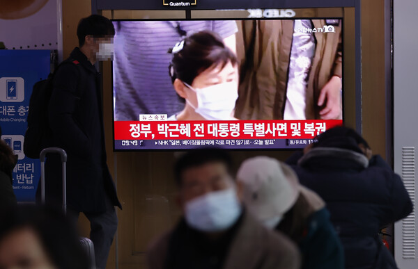 24일 오전 서울역에서 시민들이 박범계 법무부 장관의 사면 관련 발표 방송을 보고 있다. /연합