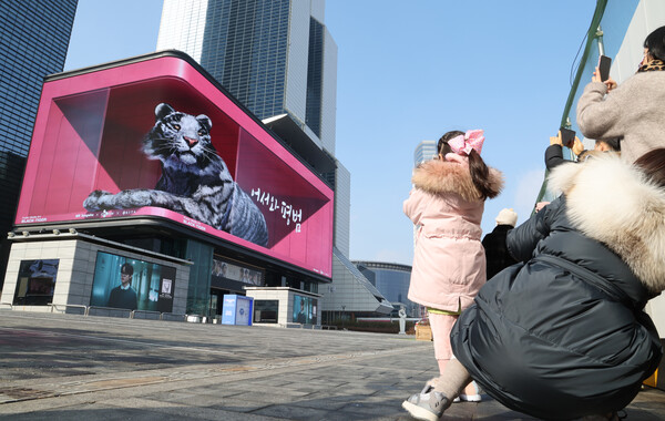 2일 코엑스 앞에서 시민들이 일상회복의 새해를 기원하는 초대형 흑호 미디어아트를 보고 있다. /연합