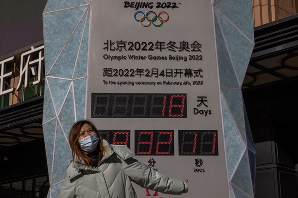 베이징 2022 동계올림픽’ 개막을 18일 앞둔 17일, 중국 베이징 시내 쇼핑가 카운트다운 시계 앞에서 한 여성이 포즈를 취하고 있다. 베이징동계올림픽은 내달 4일 개막해 20일까지 열린다. /EPA=연합