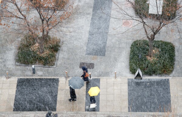 19일 오전 수도권에 대설주의보가 내려진 가운데 서울 광화문에 시민들이 우산을 쓰고 출근길을 서두르고 있다.