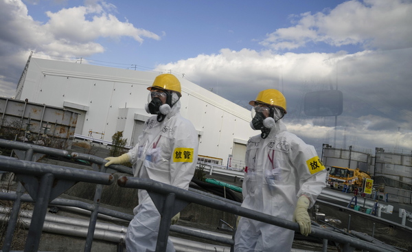 일본 후쿠시마현 오마에 있는 후쿠시마 제1원전에서 2011년 방호복 입은 인부들이 오염수 처리시설인 다핵종제거설비(ALPS) 옆을 지나가고 있다. 일본 정부와 원전 운영 주체인 도쿄전력은 2011년부터 시작된 해체작업이 30~40년 걸릴 것으로 추산했다. /EPA=연합