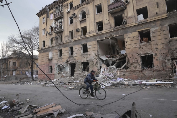 9일(현지시간) 우크라이나 남부 항구도시 마리우폴에서 자전거 탄 남성이 러시아군 포격으로 파괴된 아파트 건물 앞을 지나가고 있다. 우크라이나군은 개전 2주 차로 접어든 가운데 러시아군에 완전히 포위된 마리우폴을 필사적으로 지키고 있다. /AP=연합