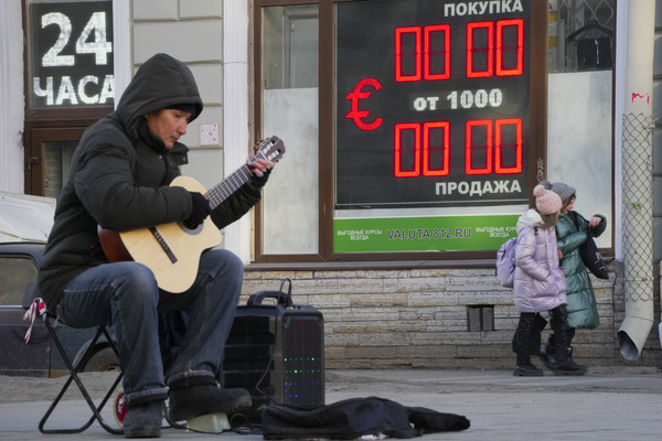 루블화와 유로화 환율 게시 중단한 러시아 환전소. 지난 9일(현지시간) 루블화와 유로화 환율의 표시가 중단된 러시아 상트페테르부르크 시내의 한 환전소 전광판 앞에서 연주자가 기타를 치고 있다. /AP-연합