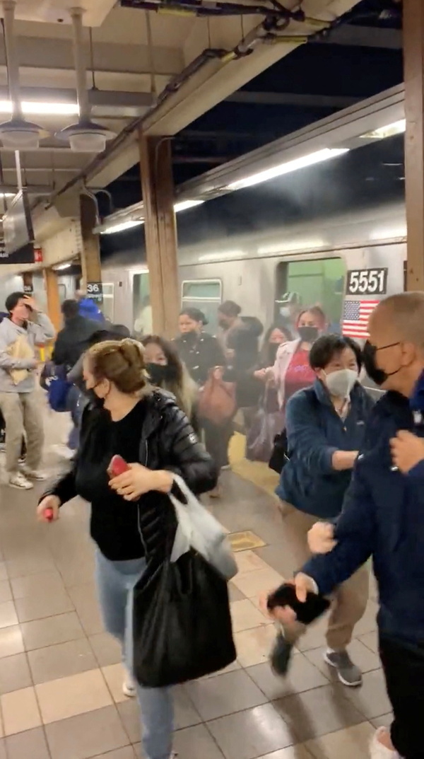 12일(현지시간) 무차별 총격 사건이 벌어진 미국 뉴욕시 브루클린 지하철역의 정차한 전동차에서 승객들이 황급히 내려 대피하고 있다. /아르멘 아르메니안 소셜 미디어 동영상 캡처