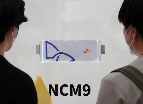 SK온 관계자들이 NCM9 배터리를 살펴보고 있다. /연합
