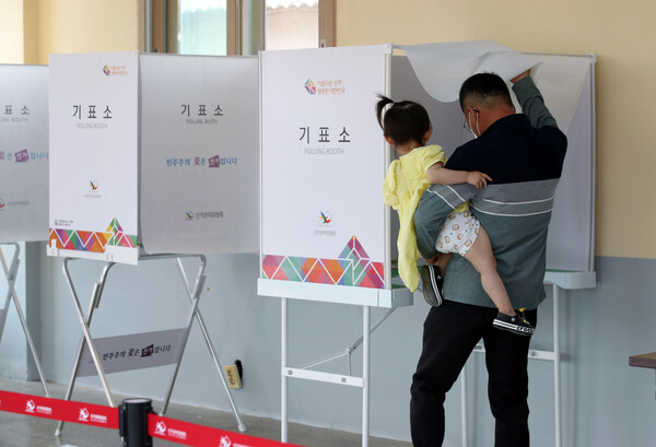 제8회 전국동시지방선거일인 1일 오전 전남 나주 문평면투표소에서 한 유권자가 아이를 안고 투표하고 있다. /연합