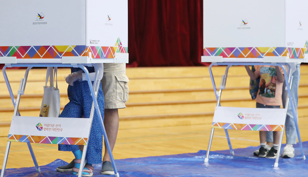 제8회 전국동시지방선거일인 1일 오후 서울 종로구 서울농학교에 마련된 투표소에 어린 자녀와 함께 온 유권자가 투표를 하고 있다. /연합