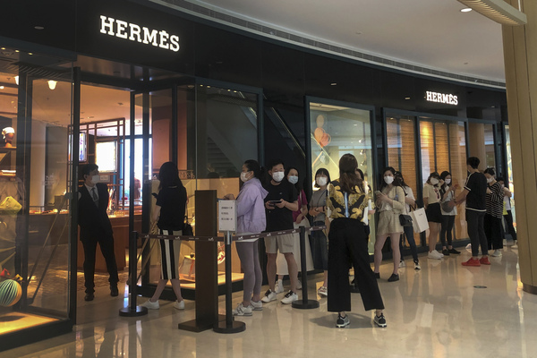 지난달 29일 영업 재개한 중국 상하이의 한 쇼핑몰 명품점 앞에 마스크를 한 방문객들이 줄지어 있다. 상하이시는 1일부터 코로나19 봉쇄를 기본적으로 풀고 정상화를 추진한다. /AP=연합