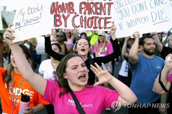 24일(현지시간) 낙태권 보장 판례를 뒤집은 미 연방대법원 판결 직후 애리조나주 피닉스에서 주의사당 건물 근처에서 시위대가 행진하고 있다. /AP=연합