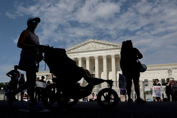 낙태권 폐지 관련 시위가 벌어지는 가운데, 한 여성이 유모차를 밀며 27일(현지시간) 미국 워싱턴 연방대법원 앞을 지나고 있다. /로이터=연합
