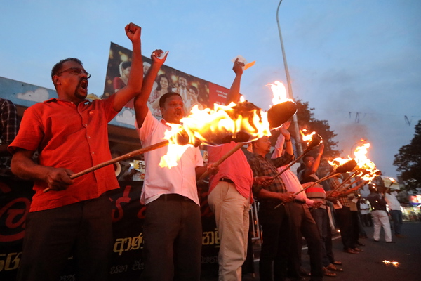 ‘국가파산’을 인정한 스리랑카의 수도 콜롬보에서 5일(현지시간) 시위대가 횃불을 들고 경제위기를 규탄하는 구호를 외치고 있다. ‘중국부채의 덫’에 빠진 스리랑카는 심각한 민생고를 겪으며 3개월 넘게 시위가 이어져 왔다. /EPA=연합