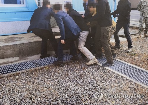 통일부는 지난 2019년 11월 판문점에서 탈북어민 2명을 북한으로 강제 송환하던 당시 촬영한 사진을 12일 공개했다. 사진은 당시 탈북어민이 몸부림치며 북송을 거부하는 모습. /연합