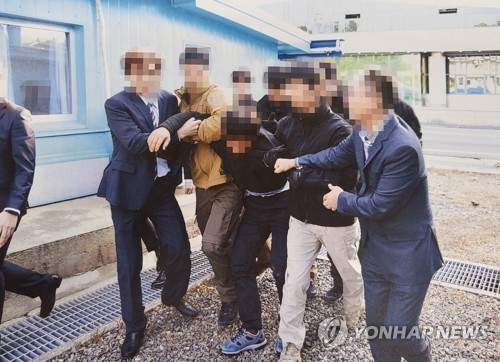 통일부는 2019년 11월 판문점에서 탈북어민 2명을 북한으로 강제송환하던 당시 촬영한 사진을 지난 12일 공개했다. 사진은 당시 탈북어민이 몸부림치며 북송을 거부하는 모습. /연합 