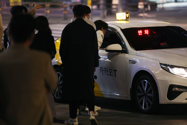 서울시가 사회적 거리두기 해제 이후 빚어지는 심야택시 대란 해소를 위해 택시 수요가 몰리는 시간대인 오후 11시~오전 2시까지 할증요율 40% 인상안 검토하고 있다고 28일 밝혔다. 사진은 서울 강남역 인근에서 빈 택시를 향해 모여들고 있는 시민들. /연합