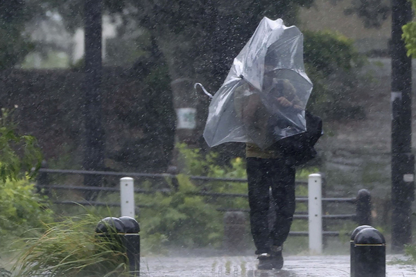 제11호 태풍 ‘힌남노’가 접근하는 가운데 3일 일본 오키나와현 나하시에서 우산을 쓴 남성이 강한 바람을 맞으며 이동하고 있다. /쿄도=연합