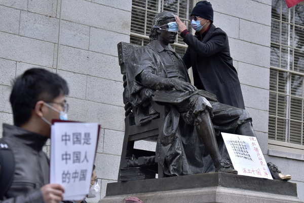 29일(현지시간) 미국 매사추세츠주 하버드대에서 학생·교직원 약 100명이 중국의 강력한 방역정책인 ‘제로코로나’에 반대하는 시위를 벌였다. 시위 도중 한 남성이 대학 창립자인 존 하버드의 동상에 마스크를 씌우며 눈을 가리고 있다. 시진핑 중국 국가주석과 제로코로나 정책에 반대하는 시위가 중국 국내외에서 연일 열리고 있다. /AP=연합