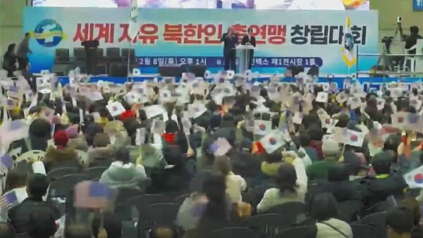 8일 세계자유북한총연맹 창립대회에 참석한 탈북민들이 함께 태극기를 흔들고 있다. /유튜브 영상 캡처