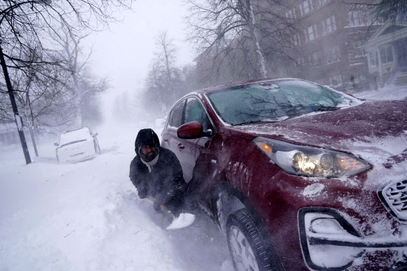 미국 시민이 24일(현지시간) 미국 뉴욕주 버펄로에서 차를 움직이려 눈을 퍼내고 있다. /AP=연합
