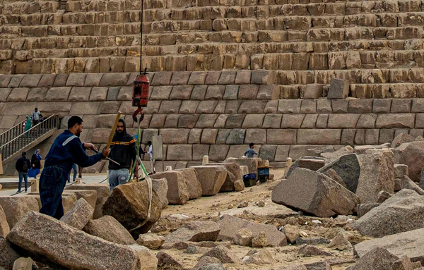 지난해 1월 29일 인부들이 이집트 멘카우레 피라미드의 복원에 쓰일 화강암을 크레인으로 들어 올리고 있다. 피라미드 하단부에는 이미 화강암 블록을 둘러싼 모습이 보인다. /AFP=연합