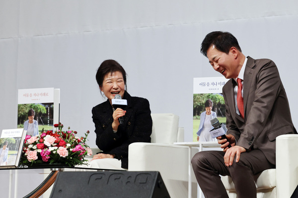 박근혜 전 대통령(왼쪽)이 지난달 5일 오후 대구 수성구 인터불고호텔에서 열린 ‘박근혜 회고록 출간기념 저자와의 대화’에서 유영하 변호사의 발언을 들으며 웃고 있다. /연합