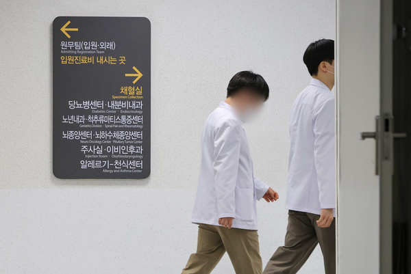 전국 의과대학 교수들의 집단 사직이 가시화하는 가운데 19일 서울 시내 한 대학병원에서 의료진이 이동하고 있다. /연합