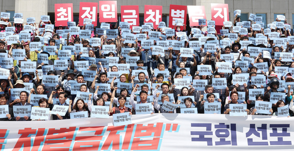 양경수(민노총), 김동명(한노총) 위원장 등 양대노총 관계자들이 3일 오전 국회 본청 앞 계단에서 최저임금 차별금지법 국회선포 기자회견을 열고 구호를 외치고 있다. /연합