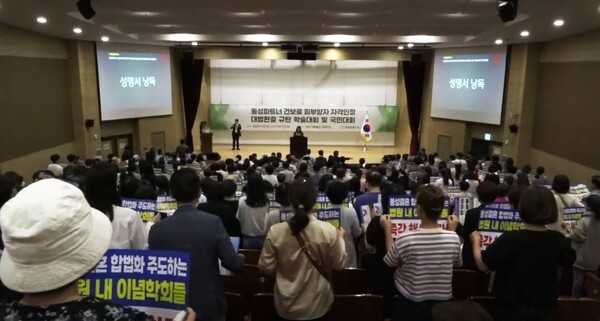 참석자들이 피켓을 들고 다 함께 일어나 성명서를 낭독하고 있다. /유튜브 영상 캡처