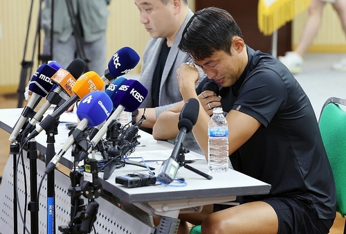 지난 11일 수원종합운동장 체육회관에서 기자간담회를 가진 손준호 선수가 중국 공안에게 겪은 일을 털어놓으면서 눈물을 훔치고 있다. /연합