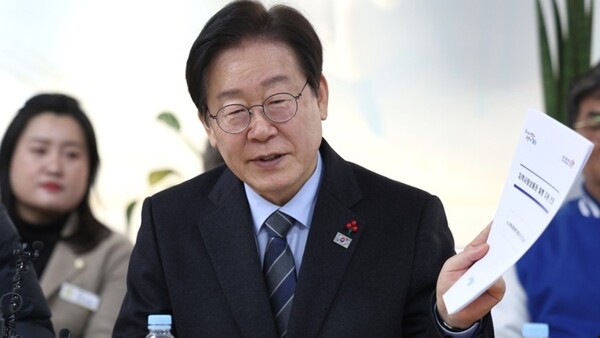 더불어민주당 이재명 대표가 1일 오후 경북 포항시 북구 죽도동 포항시전통시장상인연합회 사무실에서 열린 포항 전통시장 상인회 간담회에서 ‘지역사랑 상품권(지역화폐)’ 발행 지원 건의안을 들어 보이고 있다. /연합