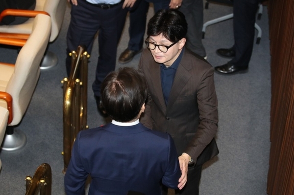 지난 4일 새벽 더불어민주당 의원의 도움으로 국회 본회의장에 들어선 한동훈 당시 국민의힘 대표가 이재명 더불어민주당 대표와 반갑게 악수하며 이야기를 나누고 있다. /뉴스1