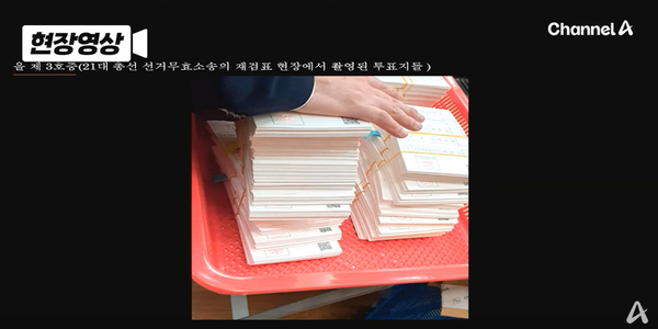 지난 21일 헌재 변론기일에서 윤석열 대통령 변호인단이 공개한 부정선거 의혹 증거사진 중 ‘신권 투표용지’ 다발. 선거법과 규칙에 따르면 투표용지는 최소한 1번 이상 정확히 접어서 투표함에 넣어야 한다. 하지만 저 용지에는 접은 흔적이 없다. /채널A 유튜브 ‘현장영상’ 캡처