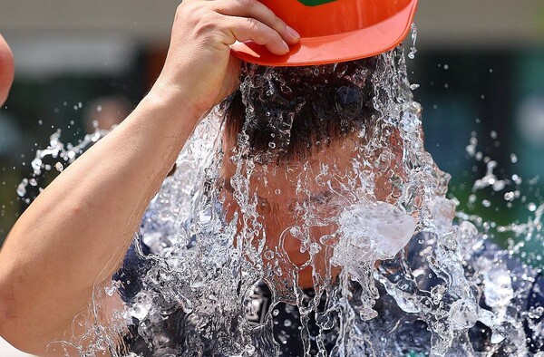 29일 서울 종로구 국정기획위원회 앞에서 열린 민주노총 건설노조 폭염 실태 기자회견이 끝난 뒤 참가자가 얼음물을 뒤집어쓰는 퍼포먼스를 하고 있다. /연합