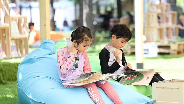 폭염이 이어진 29일 대구 수성구 수성패밀리파크에서 열린 '제9회 수성인문학제 수북수북 야외도서관' 행사에서 어린이들이 물놀이장 휴식 시간에 책을 보며 더위를 식히고 있다. /연합