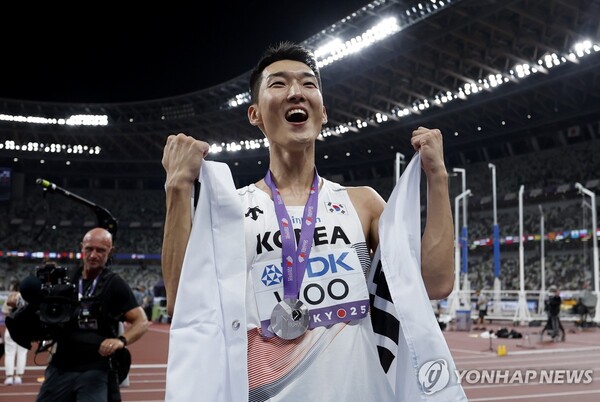 우상혁이 지난 16일 일본 도쿄에서 열린 2025 세계육상선수권 남자 높이뛰기 결선에서 2위에 오른 뒤, 태극기를 두르고 세리머니하고 있다. /도쿄 EPA=연합