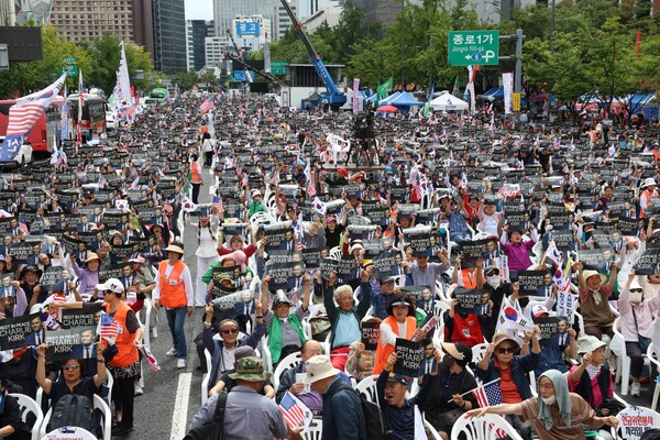 지난 20일 서울 광화문 광장에서 열린 '자유대한민국 회복을 위한 광화문 국민대회' 참석자들이 최근 작고한 미국 보수 청년 리더 찰리 커크(Charlie Kirk)를 추모하는 문구가 적힌 피켓을 함께 들어 보이고 있다. /대국본