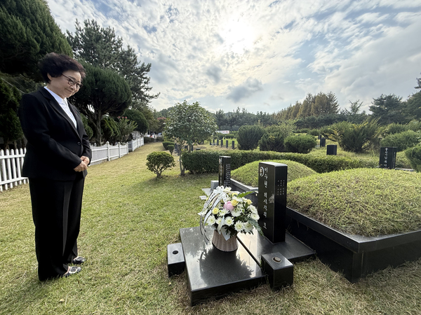 한일 우호의 상징인 의인 이수현씨 모친인 신윤찬 LSH 아시아장학회 명예회장이 30일 오후 부산 영락공원 이수현씨 묘에서 이시바 시게루 일본 총리가 놓고 간 꽃을 바라보고 있다. /연합