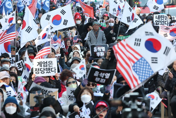 내란 우두머리 혐의로 기소된 윤석열 전 대통령의 1심 선고가 열리는 19일 서울 서초구 서울중앙지방법원 인근에서 지지자들이 손팻말을 들고 있다. /연합